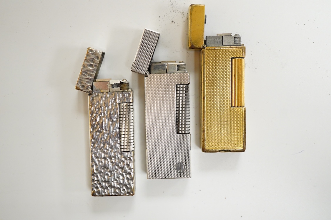 Three assorted plated Dunhill lighters and a gilt example, largest 6.5cm high